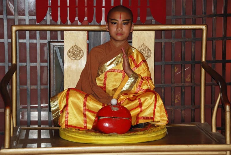 Il giovane monaco all'ingresso della sala principale del Teatro Rosso